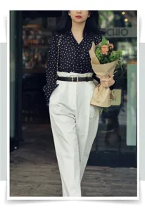 Fashionable black leather belt with gold buckle styled on a model in a cafe setting