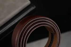 Vue rapprochée montrant la texture riche et les coutures fines d'une ceinture en cuir.