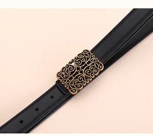Close-up of vintage bronze filigree buckle on a black leather waist belt for dresses