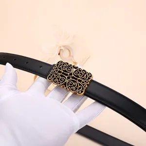 Vintage black leather belt for women featuring an intricate gold filigree buckle detail.
