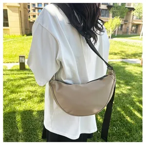Minimalist khaki dumpling crossbody bag shown as a casual outdoor lifestyle fashion wear