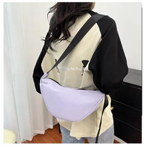 Detailed back view of a light purple crescent crossbody bag worn over a casual sweatshirt