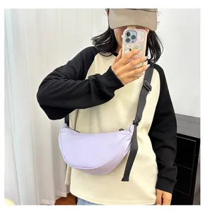 Detailed view of the light purple minimalist crescent crossbody bag worn by a model