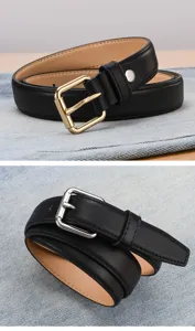 Close-up of black leather belts with gold and silver buckles on denim background