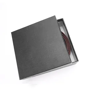 Classic men's leather belt presented in a textured black premium gift box detail view