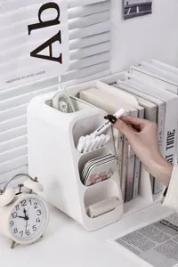 Detail of white multi-grid desk organizer with pens and books