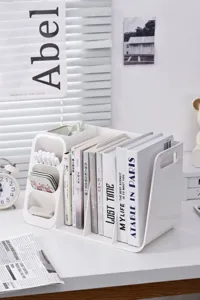 Detailed macro shot of white plastic desk organizer holding various books and pens on desk.