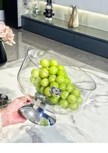 Détail d'un compotier de luxe en verre avec un socle argenté et un nœud décoratif.