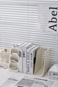 Close-up of minimalist cream desktop organizer with book storage and compartments