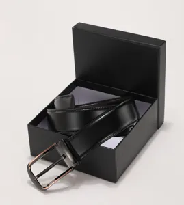 Close-up of a men's black leather business belt inside a minimalist black gift box