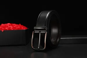 Detailed view of black leather belt with gunmetal pin buckle and rose gold edge