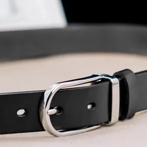 Detailed close-up showing the silver pin buckle and texture of a black leather belt