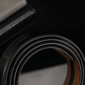 Primer plano del borde de la correa de cuero negro de 3,5 cm con costuras finas y forro marrón