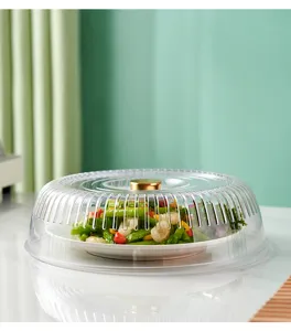Clear ribbed plastic food cover with elegant gold handle protecting fresh vegetable dish