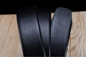 Gros plan de la texture de la ceinture en cuir noir à motif litchi