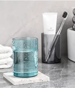 Detailopname van een lichtblauwe doorschijnende plastic beker met waterdruppels