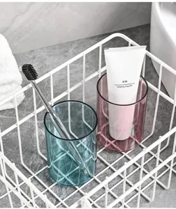 Set van transparante plastic tandenborstelbekers met witte draadmand voor badkamer