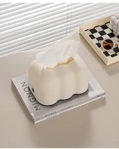 Portafazzoletti color crema a forma di nuvola su una rivista elegante in casa.