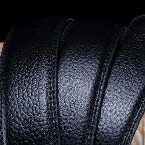 Gros plan d'une ceinture en cuir noir pour hommes avec texture litchi et surpiqûres.