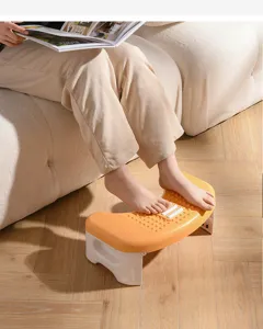 Ergonomic plastic footstool with massage rollers used under desk for foot comfort.