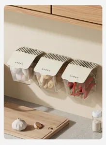Detail view of wall-mounted transparent storage boxes with garlic, ginger and chili.