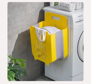 Cesto per biancheria pieghevole da parete appeso alla lavatrice in un bagno moderno.