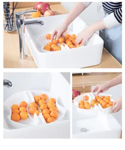Detail view of the white divided fruit tray showing bottom drainage holes in a kitchen sink.