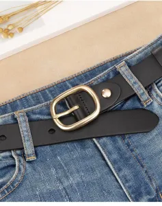 Close-up of a black genuine leather belt with a gold oval buckle on blue jeans.