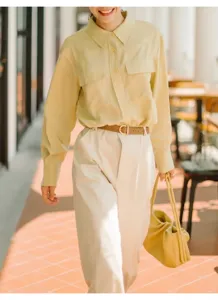 Elegant brown leather belt for women with gold D-ring buckle, styled on beige trousers.