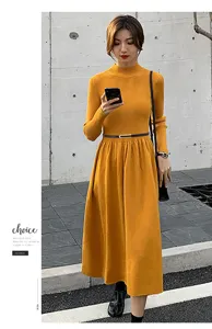 Dettaglio di una sottile cintura in pelle nera con fibbia dorata su un vestito giallo