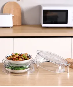 Detailed view of stackable transparent food covers protecting dishes in a kitchen setting.