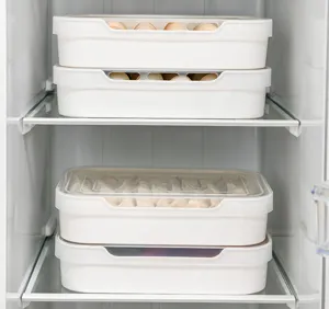 Cajas blancas de almacenamiento para frigorífico con huevos y empanadillas en la cocina