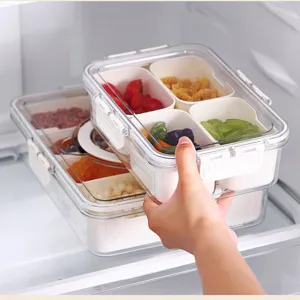 Main plaçant un bac de rangement alimentaire compartimenté en plastique dans un frigo
