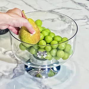 Corbeille à fruits en verre élégante avec base argentée et nœud décoratif.