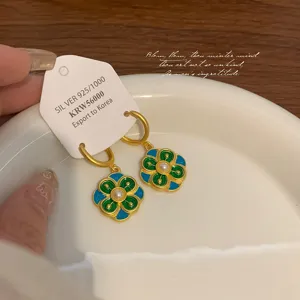 Primo piano di orecchini a cerchio a fiore in smalto cinese vintage blu e verdi