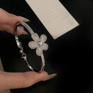Detailed close-up of a sparkling silver flower bangle featuring cubic zirconia pavé
