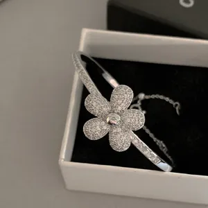 Elegant silver flower bangle encrusted with clear zircons in a jewelry gift box
