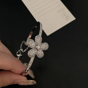 Macro detail of a silver bangle featuring a sparkling zircon-encrusted flower design