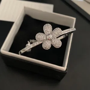 Close-up of sparkling full zircon paved flower bangle in elegant silver finish for women