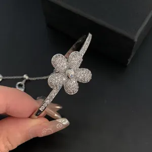 Macro detail of elegant flower charm bangle featuring sparkling cubic zirconia stones