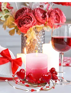 Detail view of red heart berry candle rings for romantic Valentine's Day table decor.