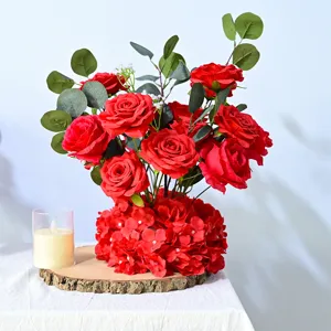 Arrangement floral de roses rouges artificielles pour décoration de table de mariage.