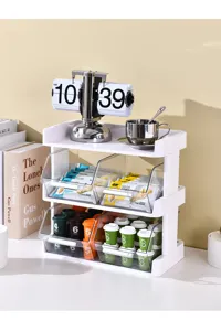 Detail of the three-tier white desktop storage rack for coffee capsules and tea bags.