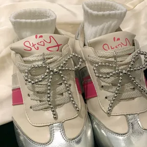 Close-up of silver beaded bow shoe charms attached to sneakers for decoration