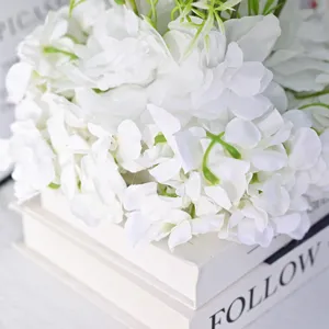 Gros plan de grappes de fleurs de soie artificielles blanches pour décor de mariage.