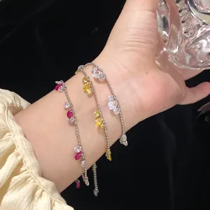 Dettaglio di collane d'argento con zirconi colorati a goccia indossate sulla mano