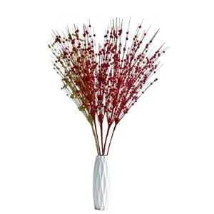 Rami di bacche glitterate di Natale con vaso geometrico bianco per decorazione festiva
