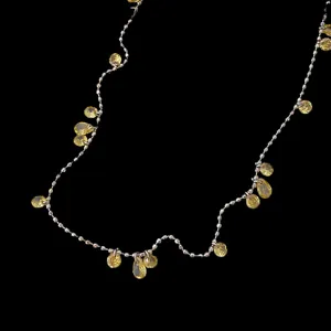 Primo piano di collana di lusso francese con pendenti in zirconia gialla scintillante.