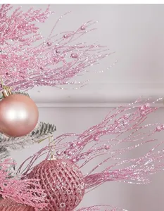 Gros plan de branches pailletées roses et boules à paillettes pour Noël