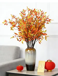 Detail of artificial Sacred Bamboo berries and foliage arranged in a glazed ceramic vase